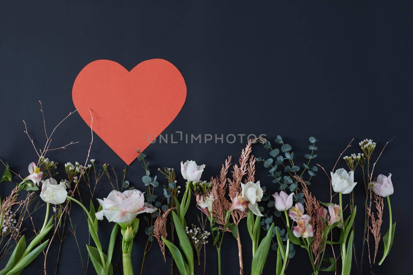 Paper heart on a dark background surrounded by flowers by Demkat