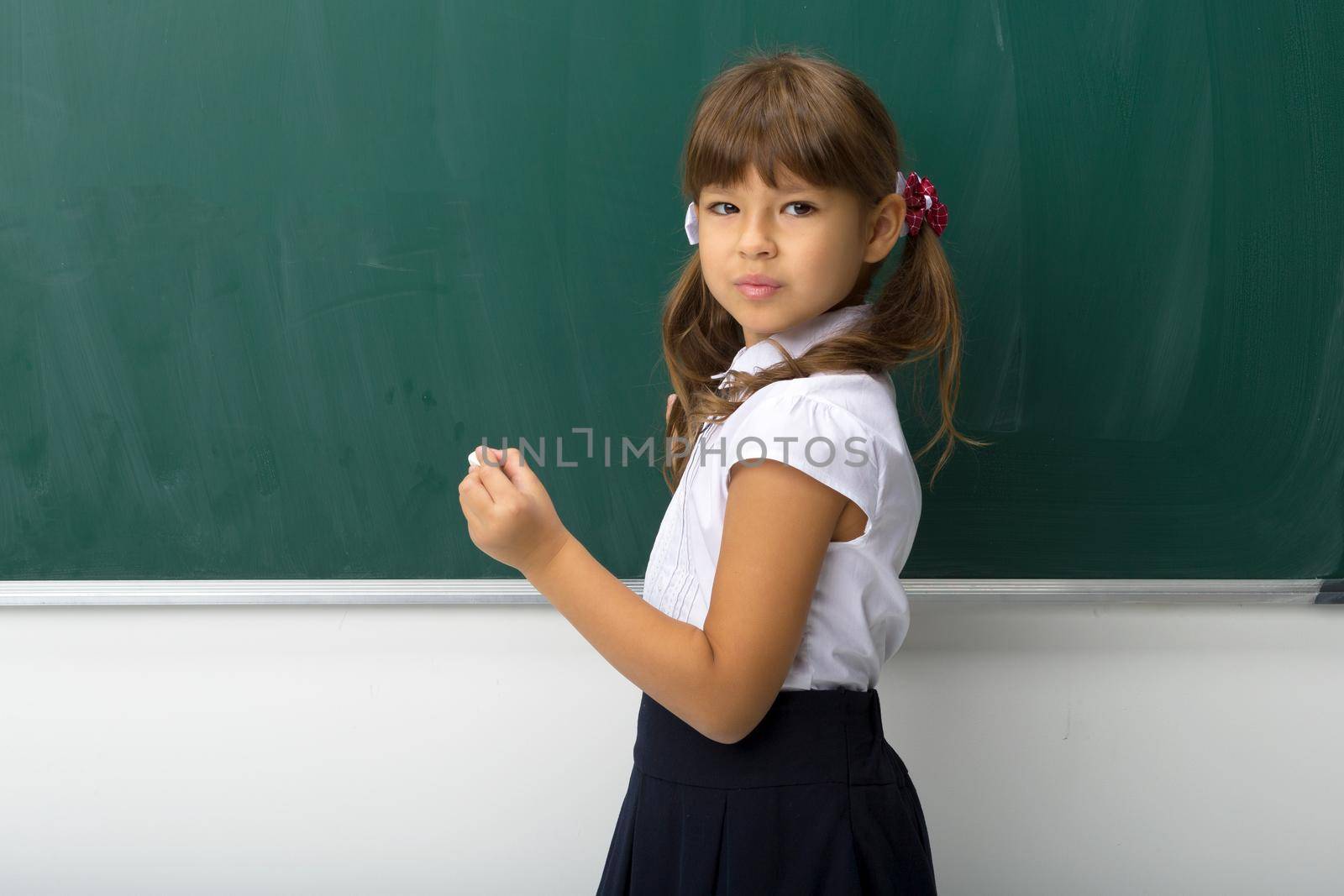 Pretty girl posing at blackboard by kolesnikov_studio