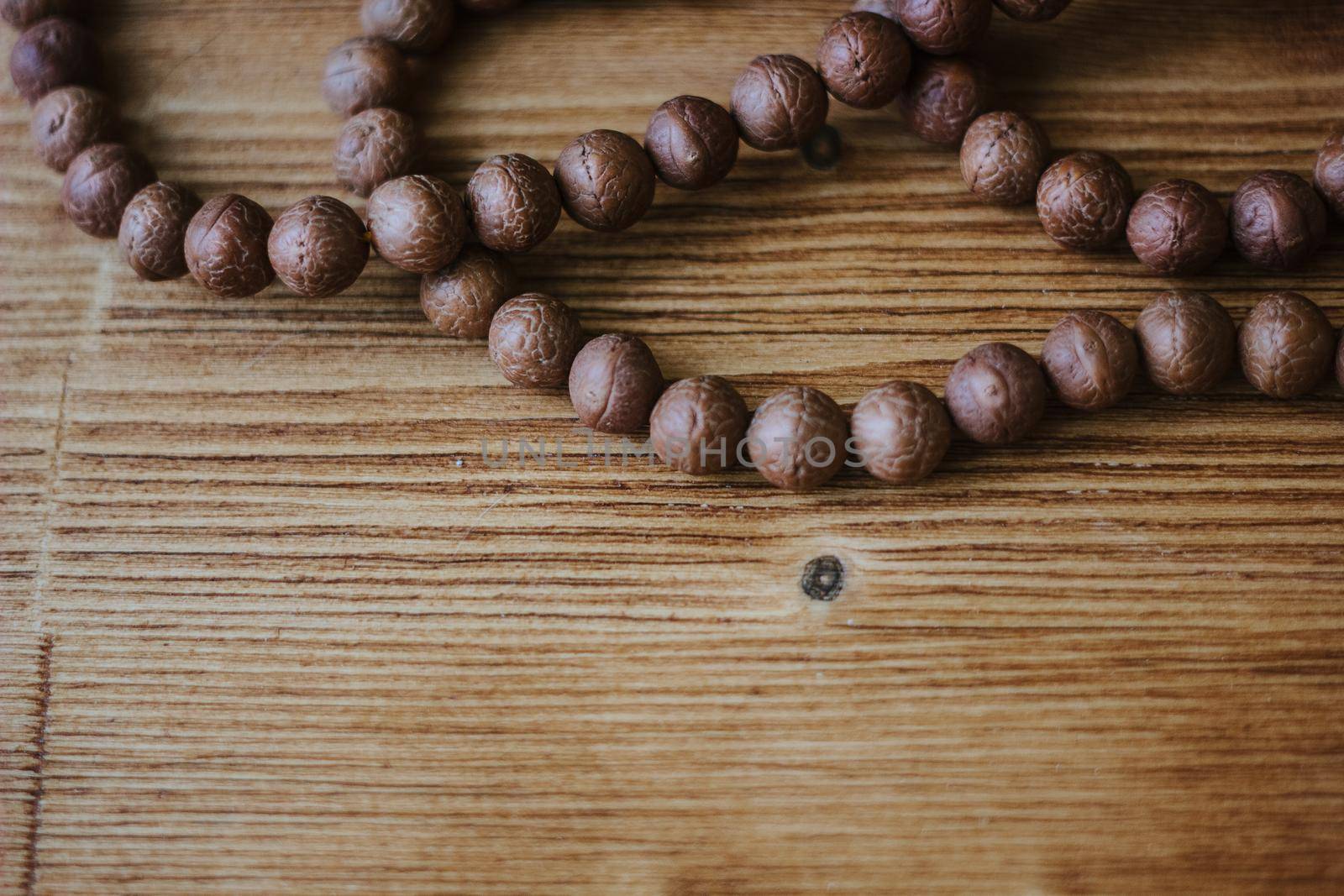 Rudraksha hindu rosary on brown wooden background