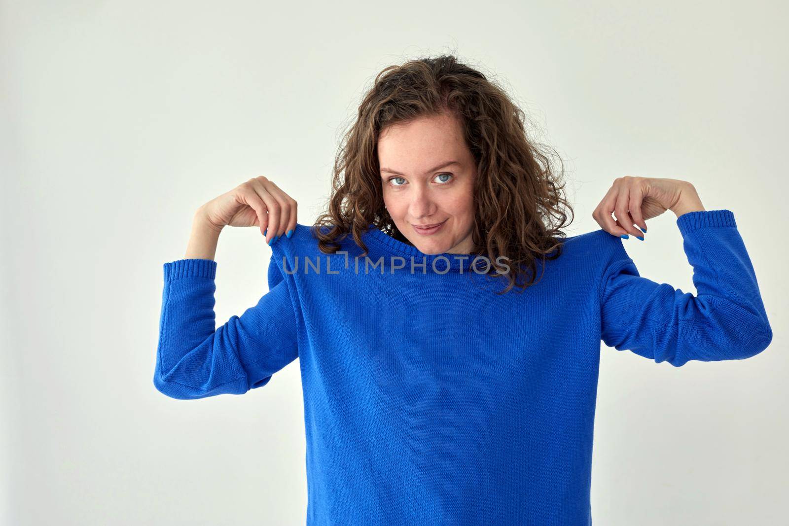 Smiling woman in blue knitted sweater white background by Demkat