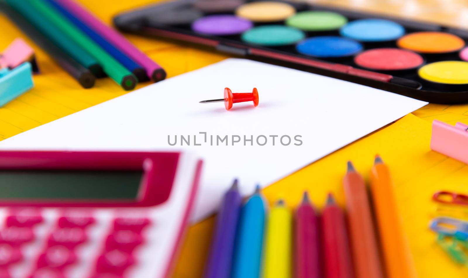 School office supplies stationery on a orange paper background with copy space. Back to school concept.