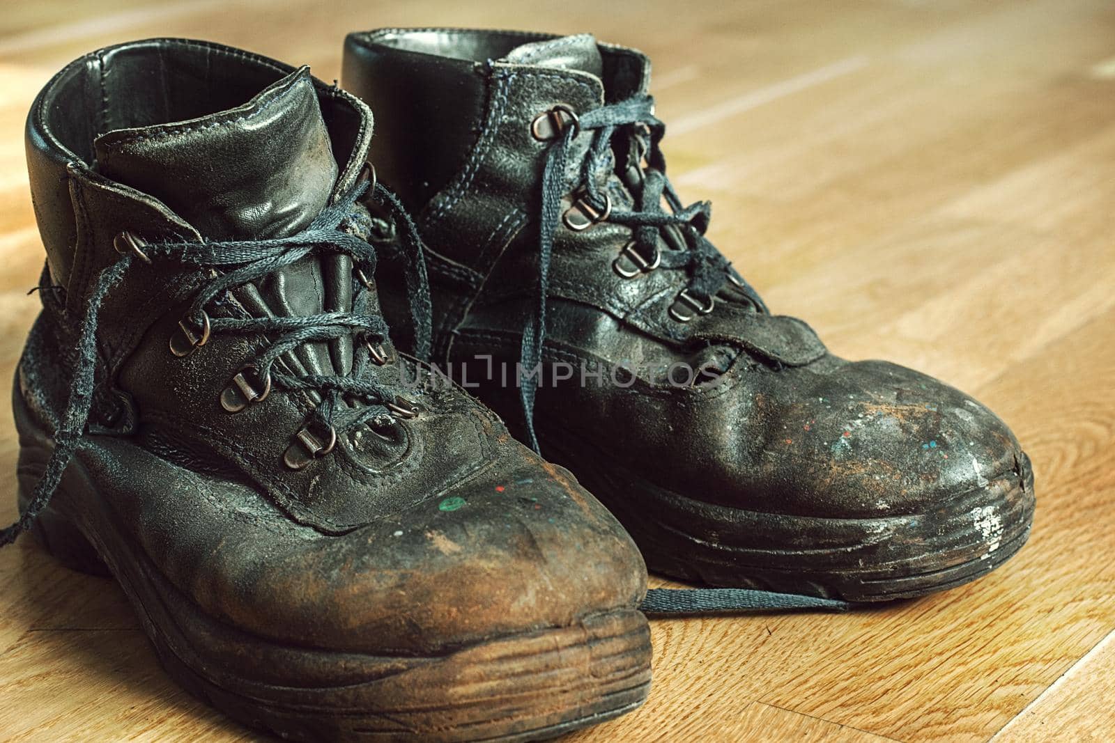 Old worn work boots with lacing. Leather shoes that require repair or replacement. Closeup