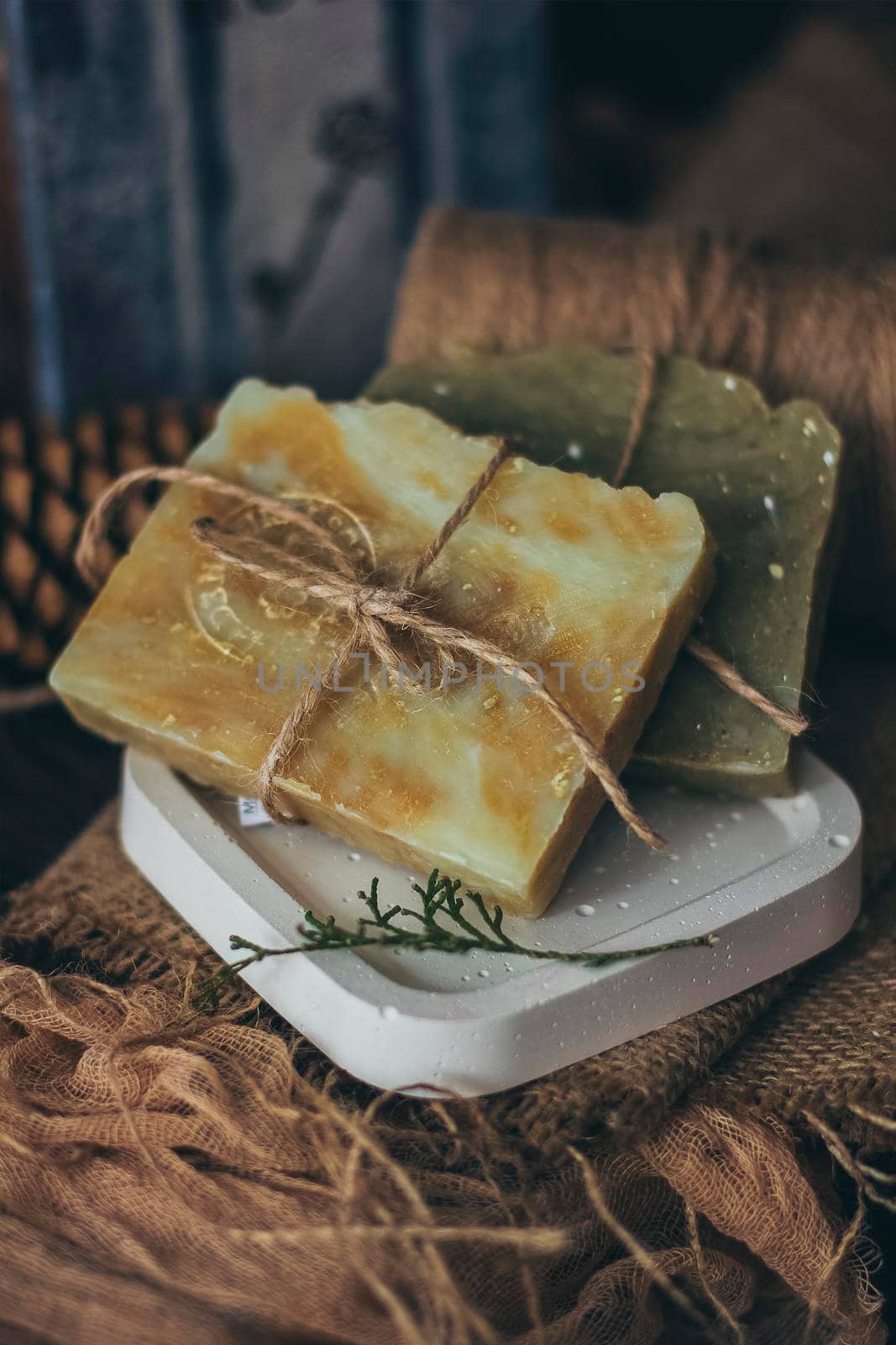 Pieces of beautiful natural handcrafted soap on wooden background with botanical elements, close up view. For relax, health, spa and aromatherapy