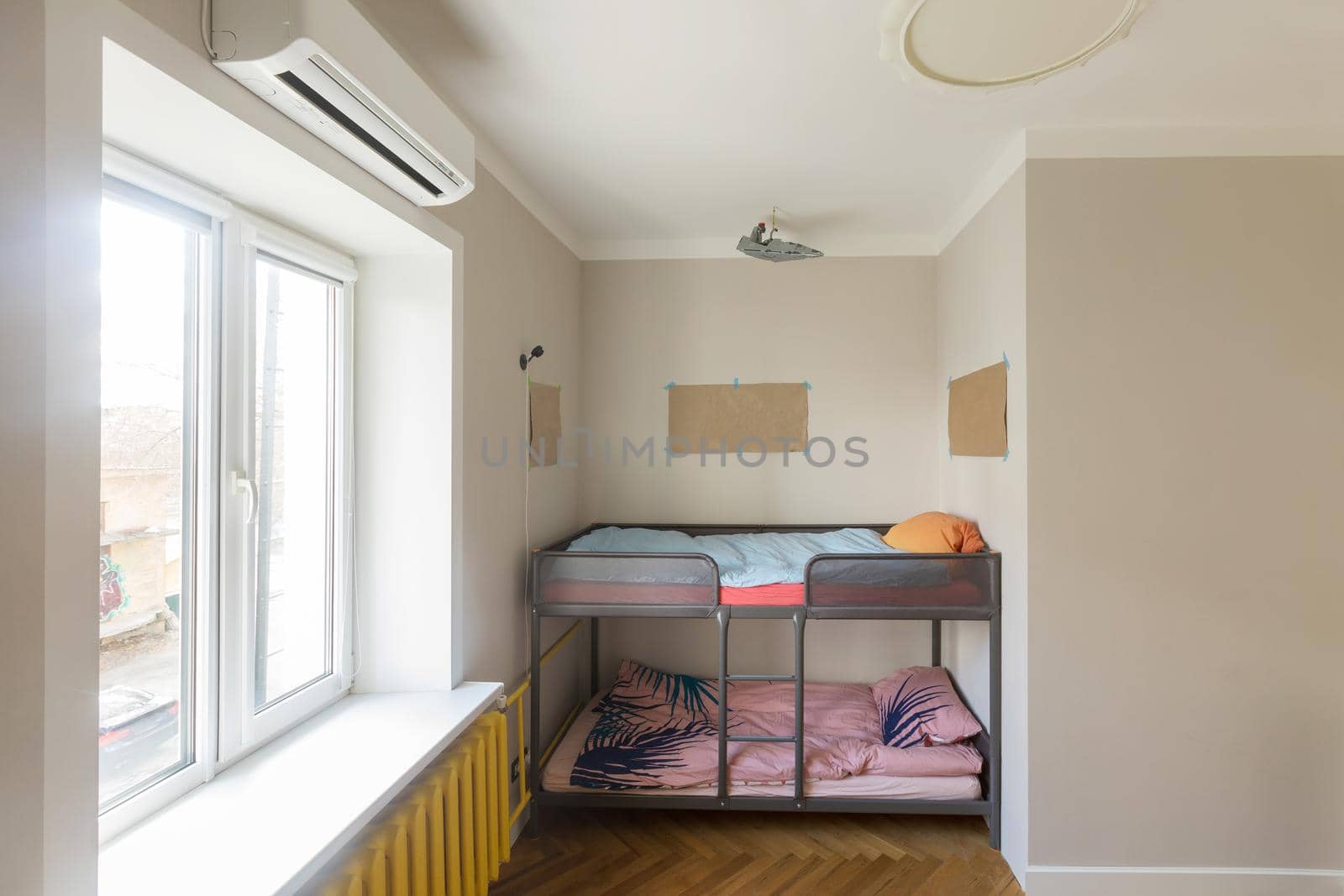 Fragment of modern home interior with bunk bed placed in niche near window in contemporary small apartment with minimalist style design. Children's room