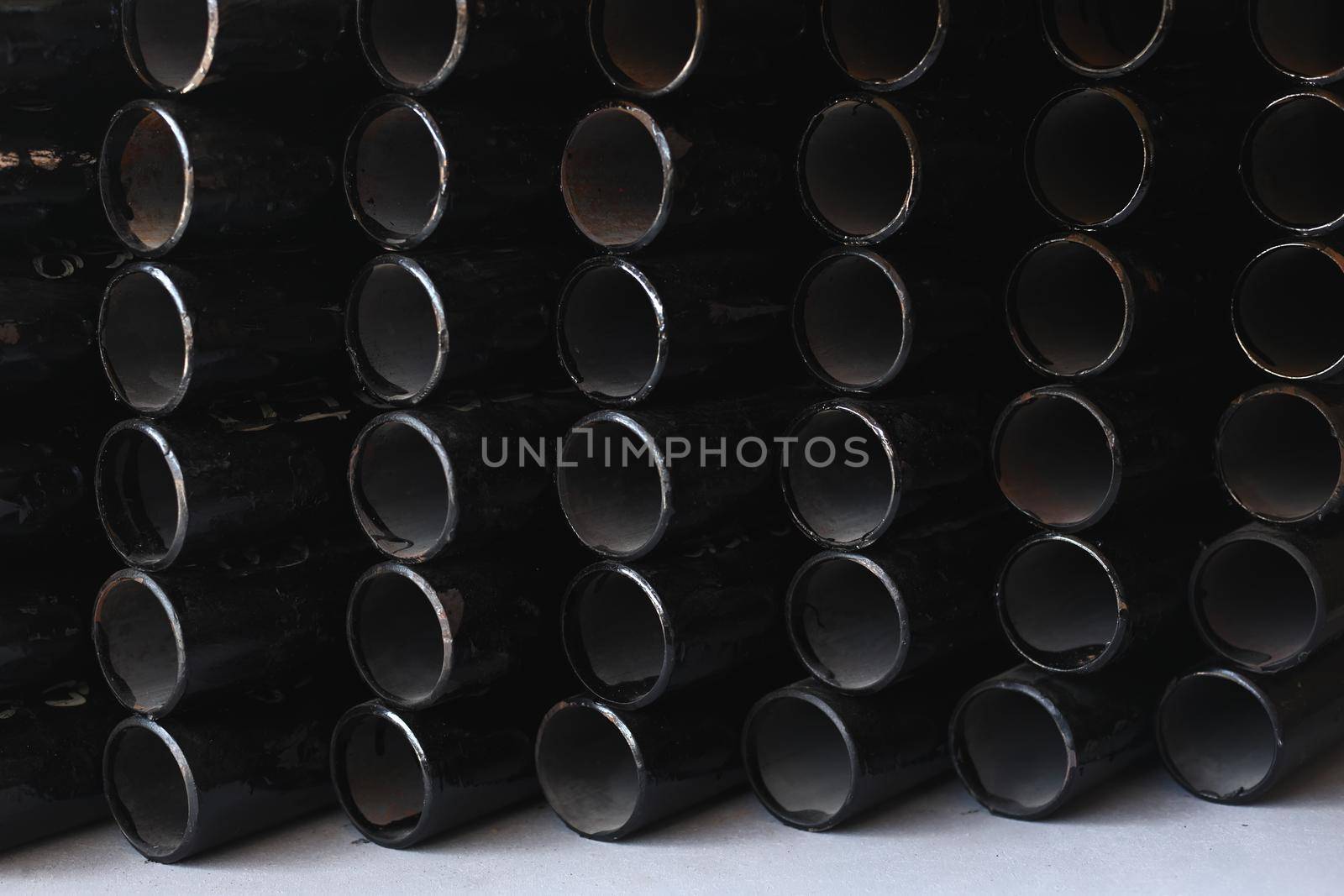 Black metal pipes for gasification or water supply. Industrial background close up.