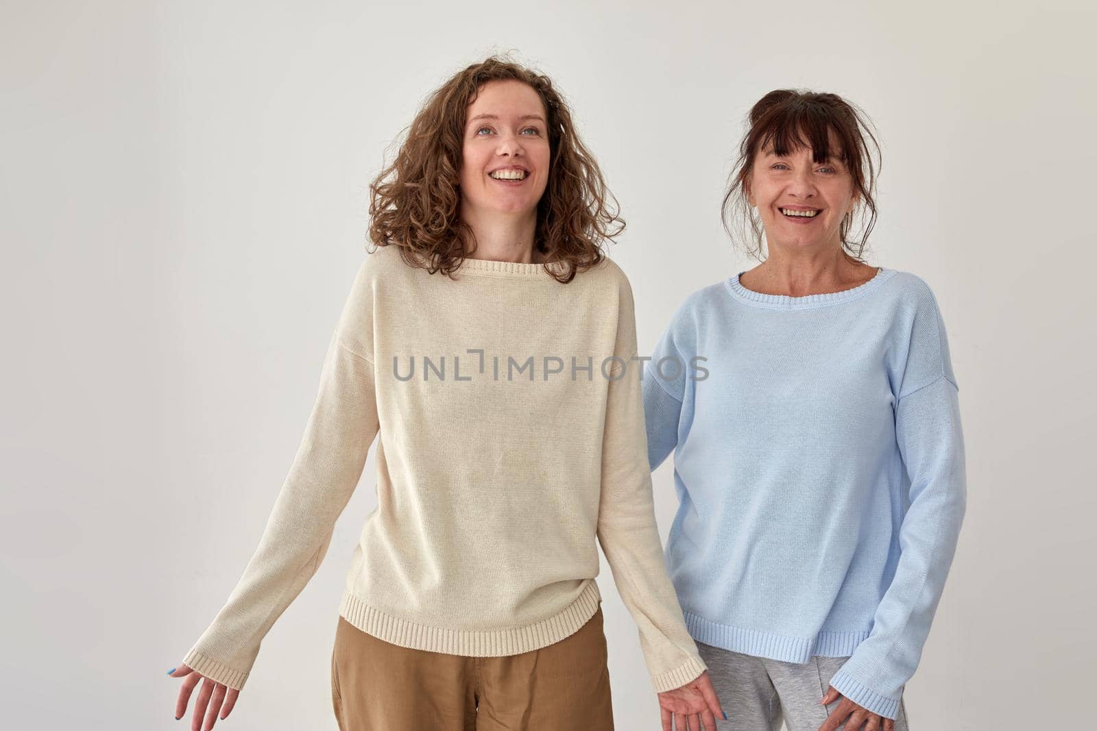 Positive mature mother and adult daughter in studio by Demkat