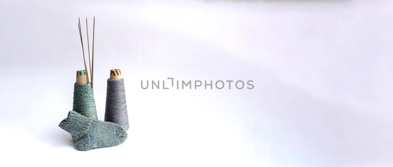 Sock, thread, needles are on white background, isolated, knitting concept.