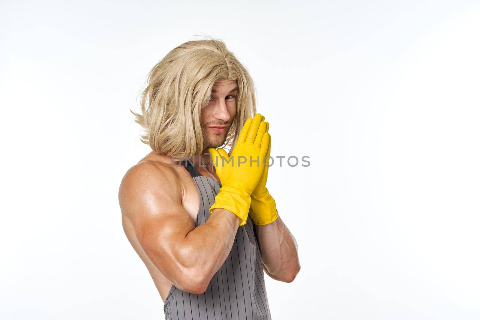 man in yellow rubber gloves in a woman's wig cleaning posing. High quality photo