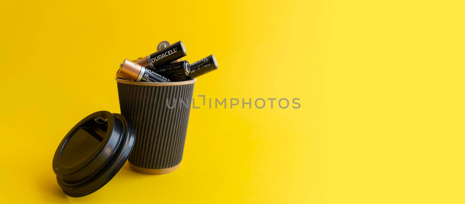 Kiev, Urkaine, 16 June 2020, Duracell AA alkaline batteries are in coffee takeaway cup as association of energy, yellow background, creative idea of using batteries. Enough space for text.