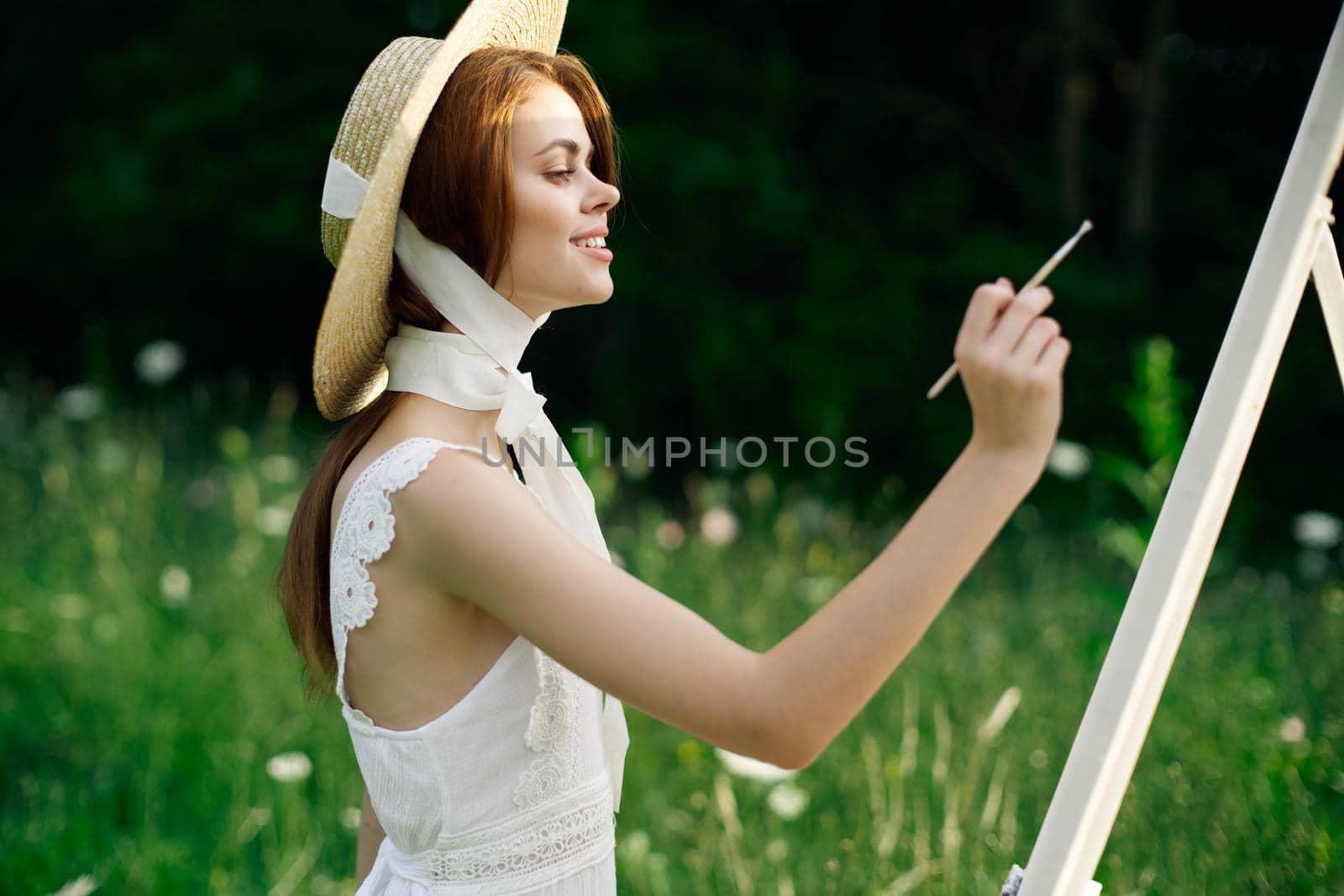 Woman in white dress paints a picture on nature easel by Vichizh