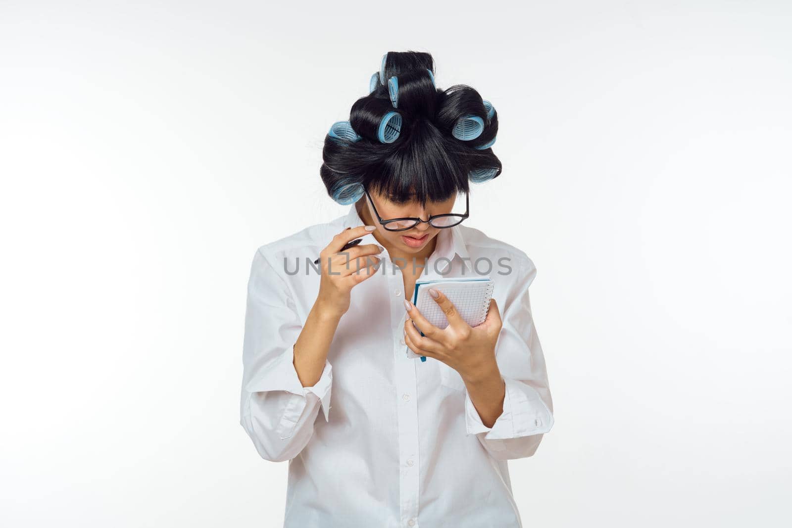 Woman in white coat curlers on her head homework. High quality photo