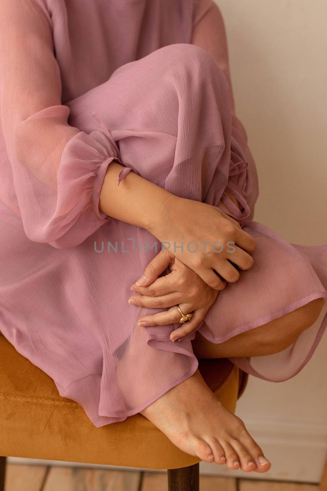 Crop woman in translucent dress embracing knee by Demkat