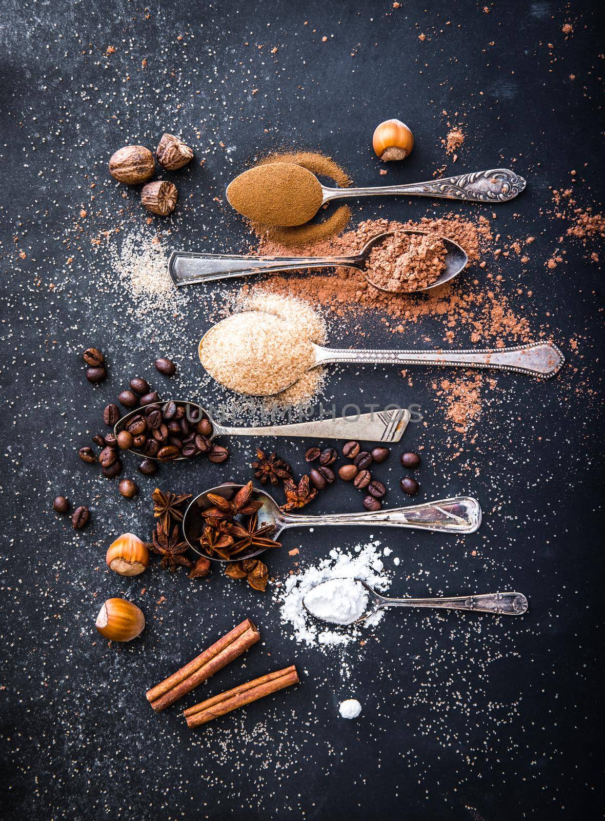 Sweet spices in the spoons on the table a black background