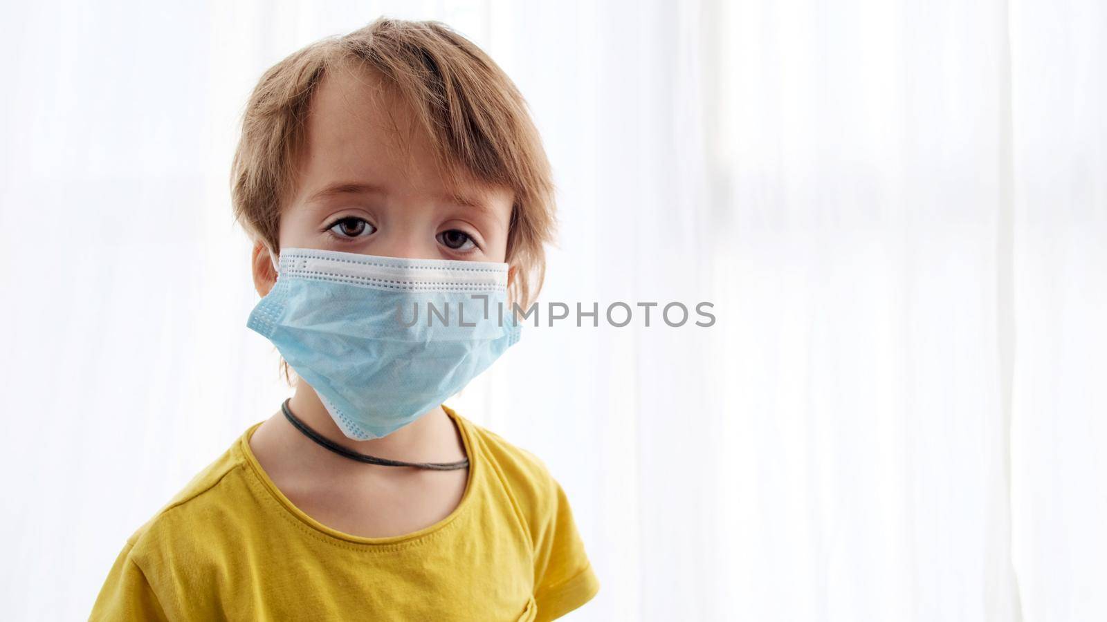 Young boy in mask white background looking at camera coronavirus. Masked face boy protect health covid-19. Portrait little child in medical masks. Cute kid in quarantine epidemic corona virus covid 19