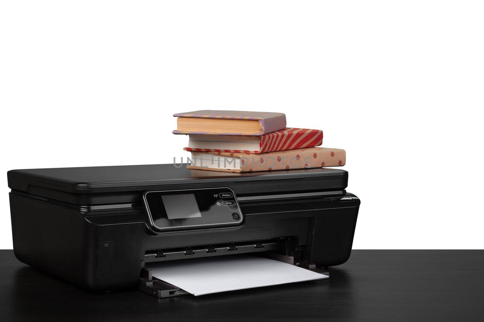 Working table with printer and stacked books on white abckground, close up