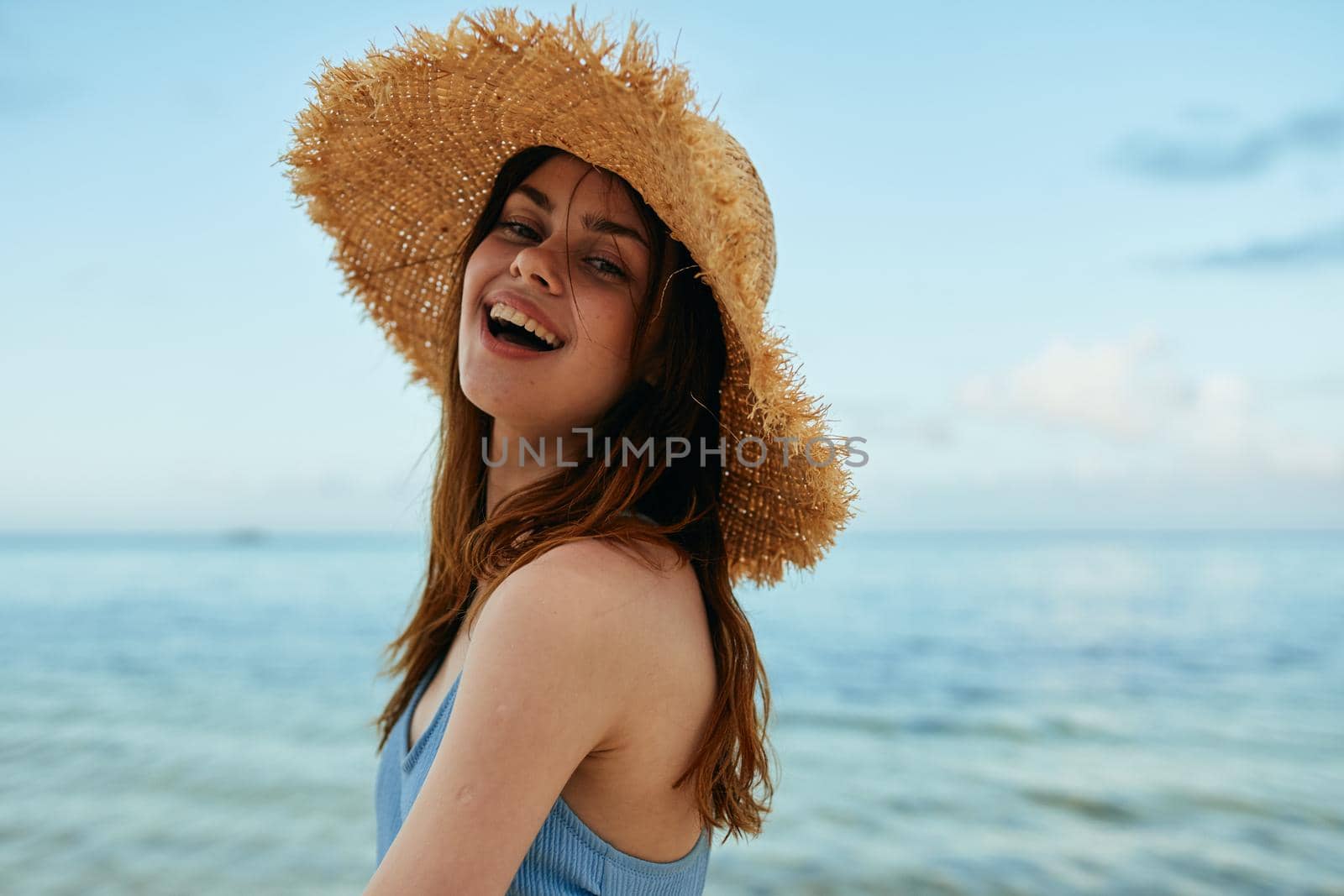 cheerful woman in a beach hat by the ocean island summer. High quality photo