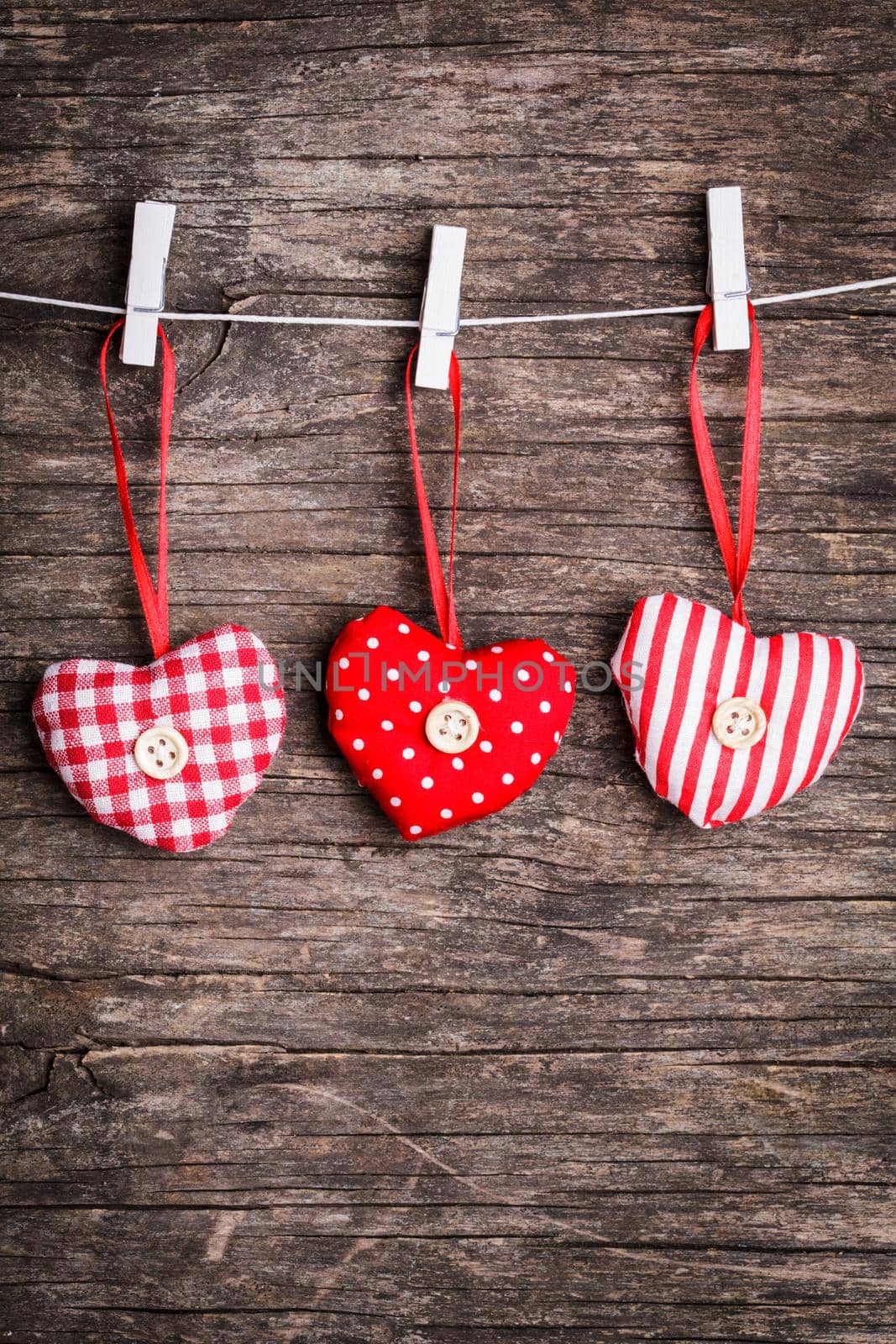 White and red sewed christmas hearts attached to the rope. Holiday background for greetings Valentine's day