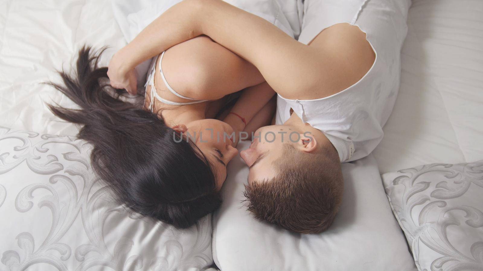 Young attractive couple cuddling and waking up together, family relationships, top view