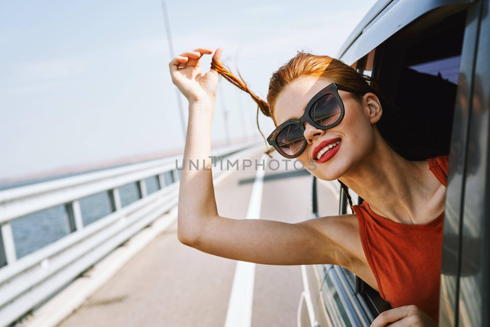 woman looking out of car window wearing sunglasses travel lifestyle. High quality photo