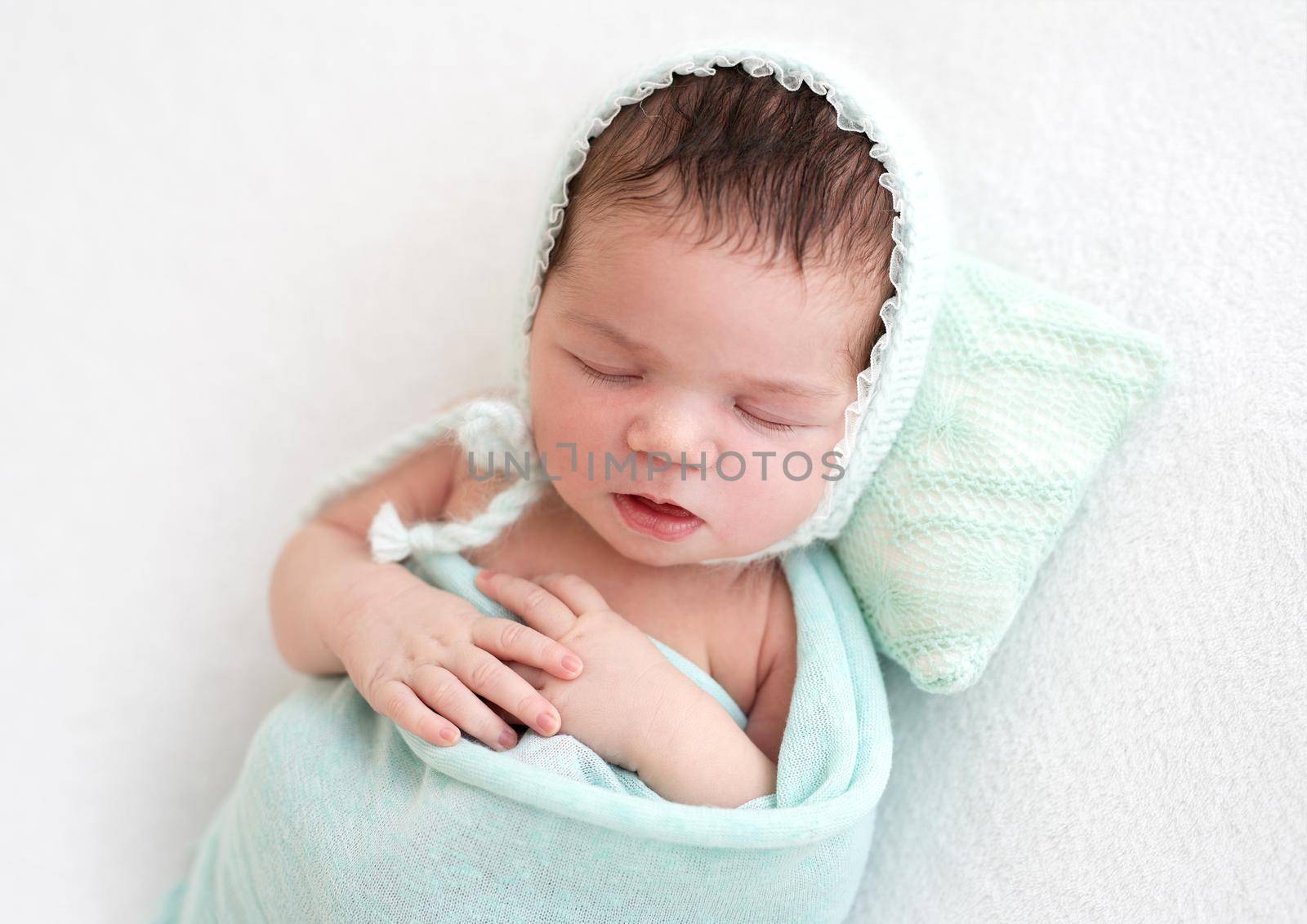 Cute newborn sleeping peacefully on tiny pillow