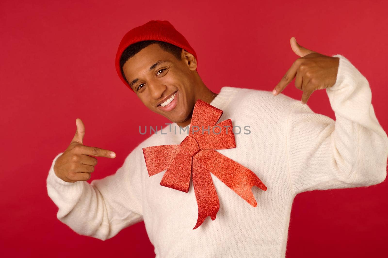 Festive mood. A young dark-skinned man in santa hat feeling joyous