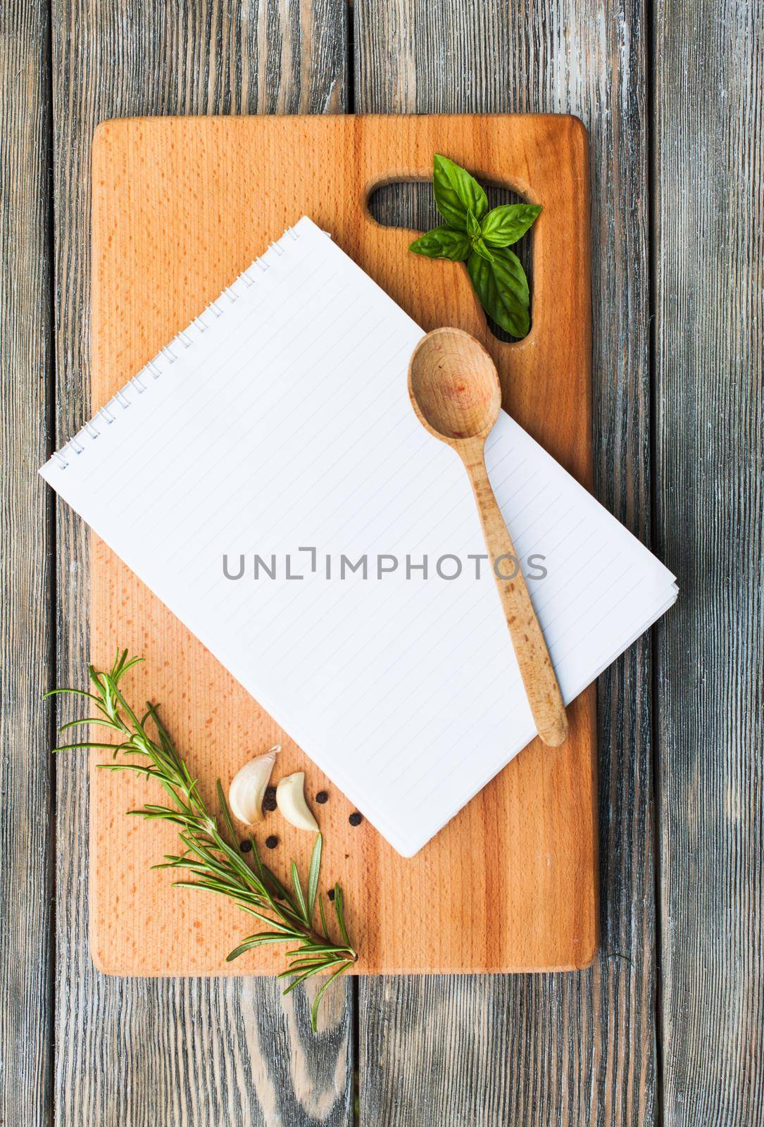 Recipe concept. Blank sheet of paper on a wooden board with spices