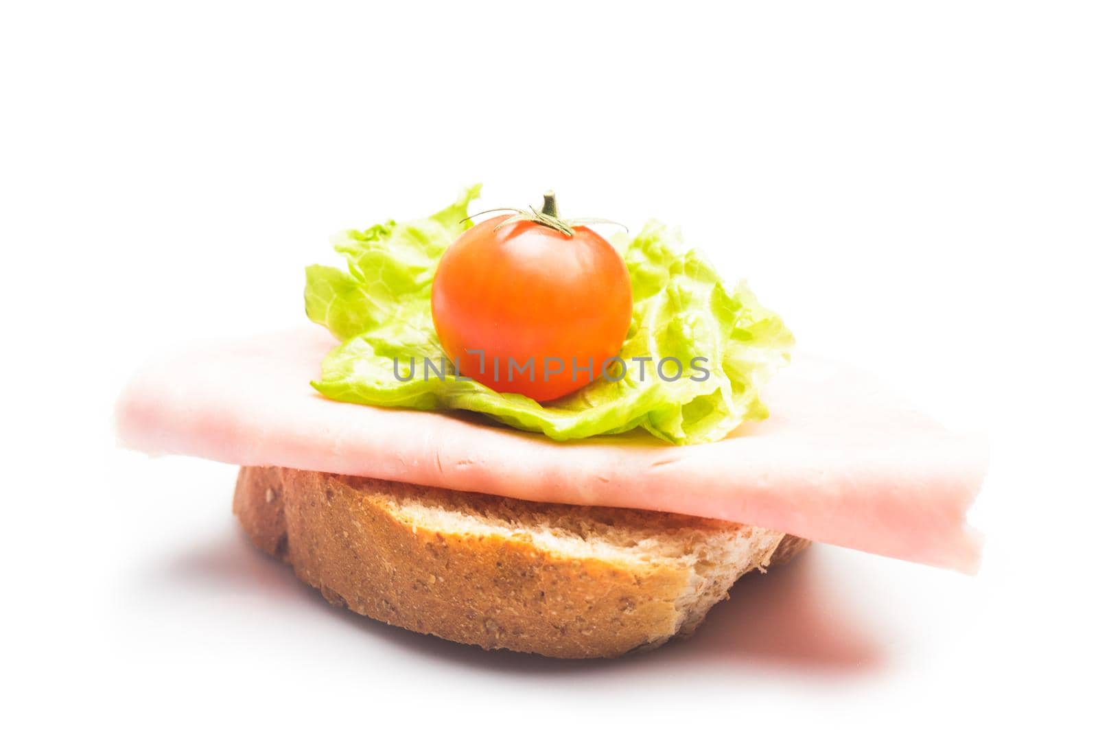 Sandwich with fresh ham slice, lattuce and cherry tomato on white