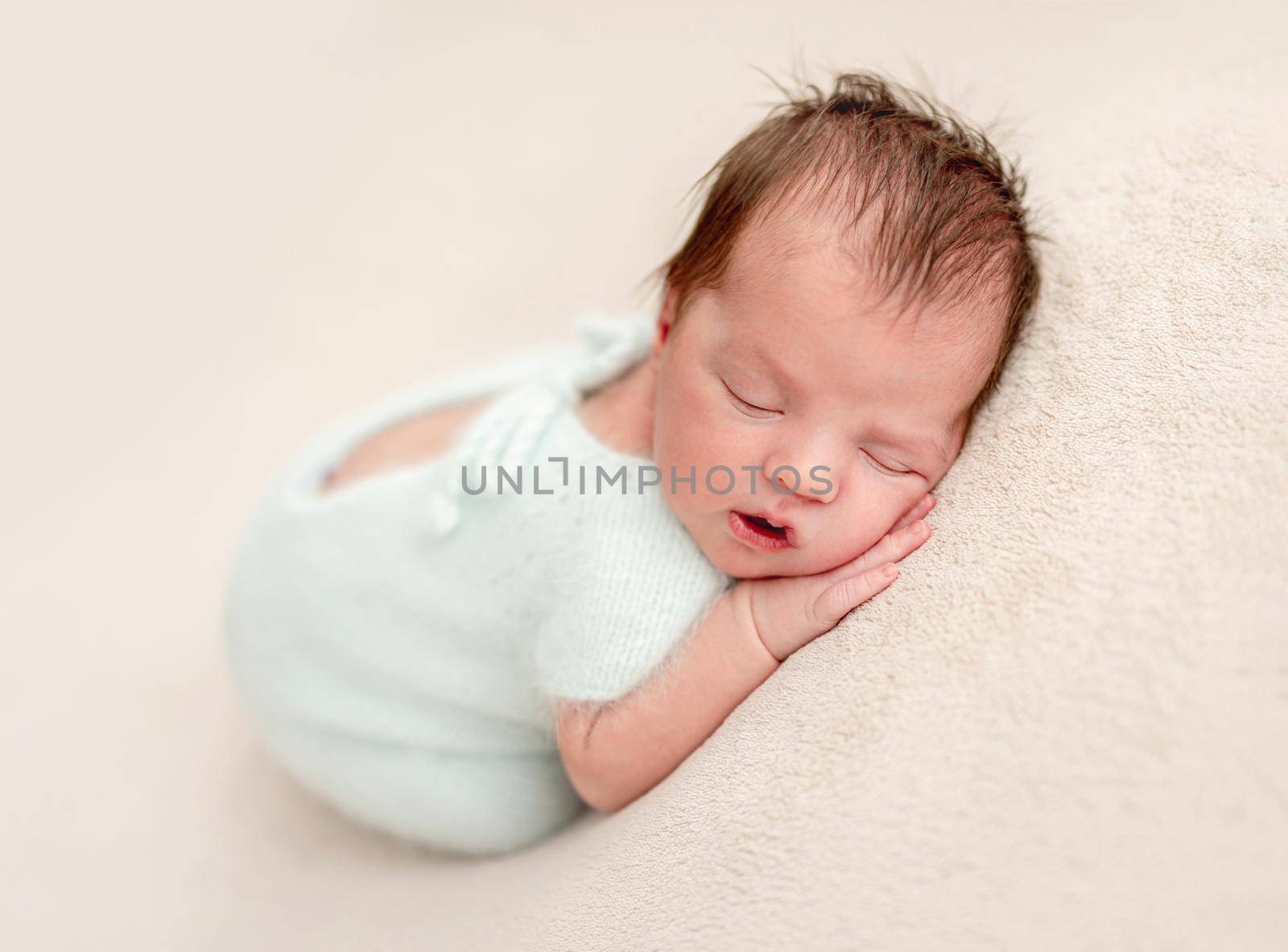 Innocent newborn angel in white knitted suit