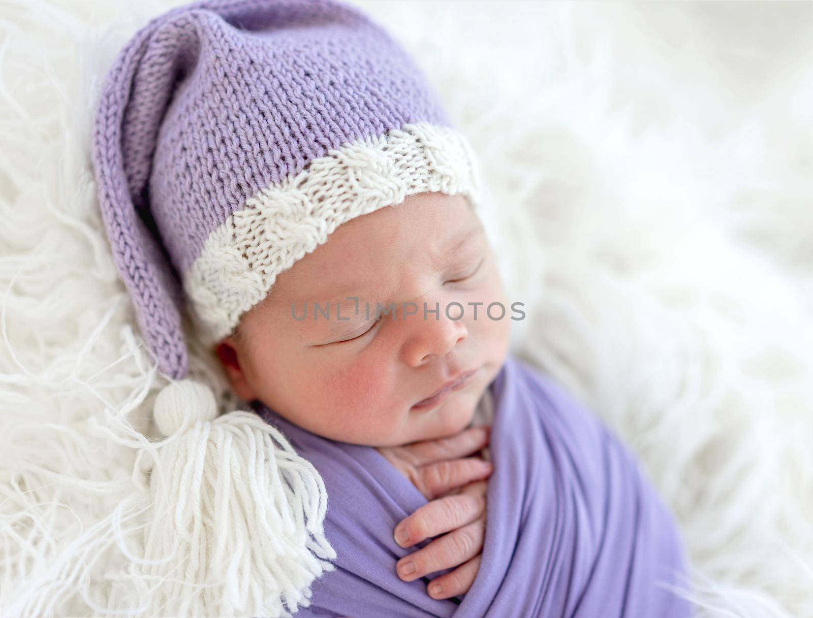 Cute newborn in knitted hat sleeping