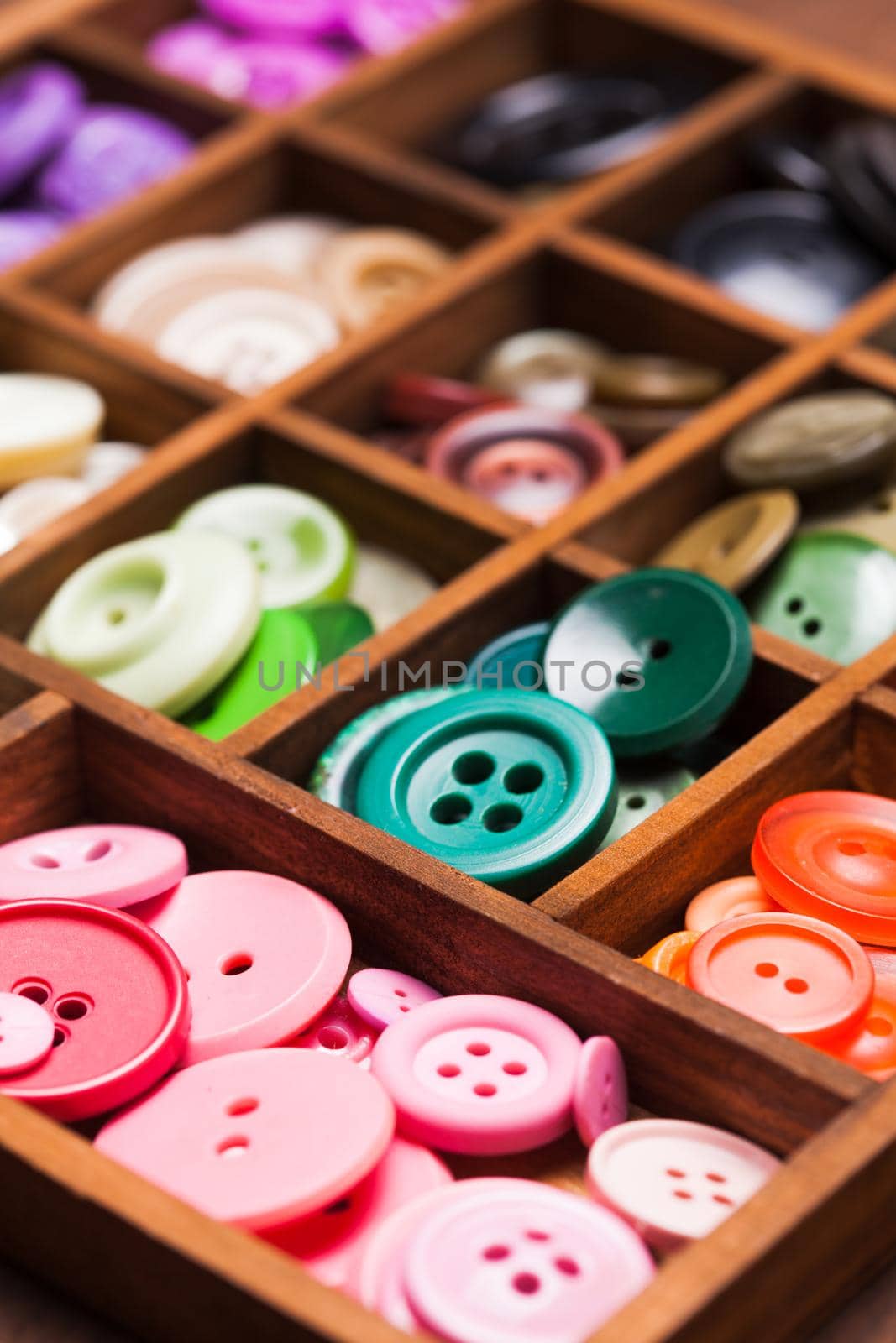 Colorful buttons in a wooden box for design