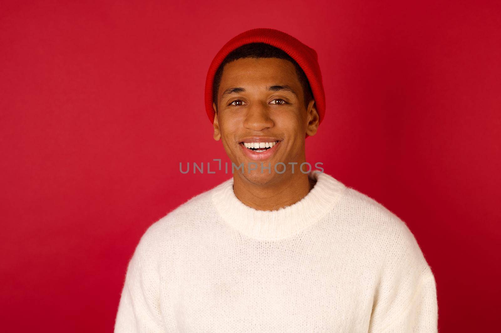 Dark-skinned young man in a santa hat by SDM_Prod_Studio