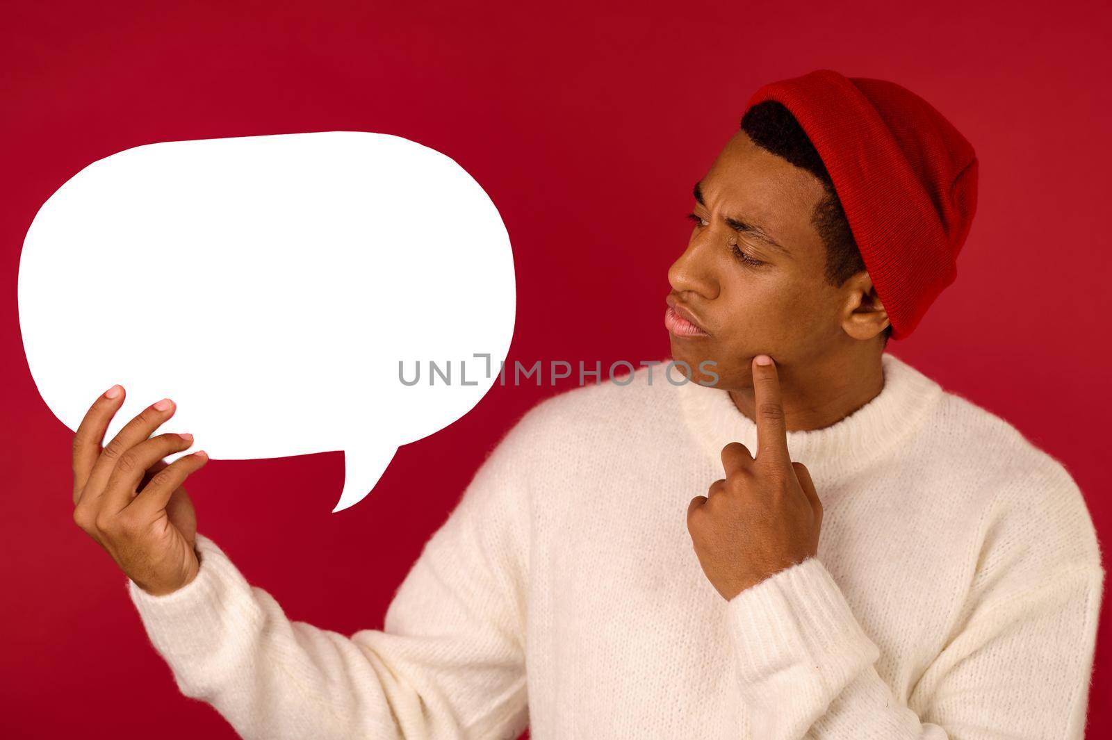 Communication. A young man in santa hat holding emoji