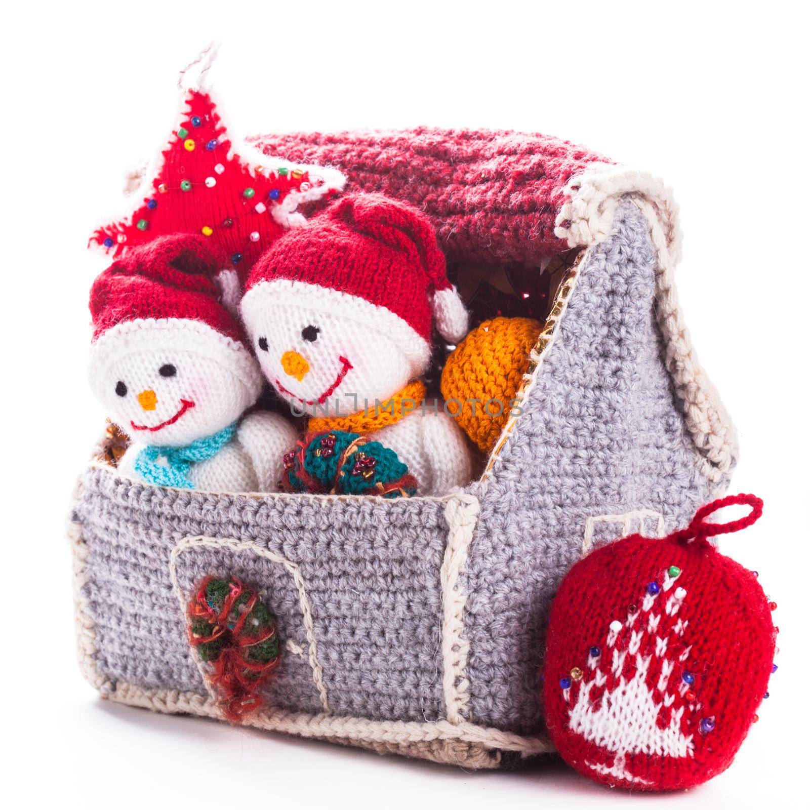 Two knitted christmas snowmen in a house and handmade christmas tree