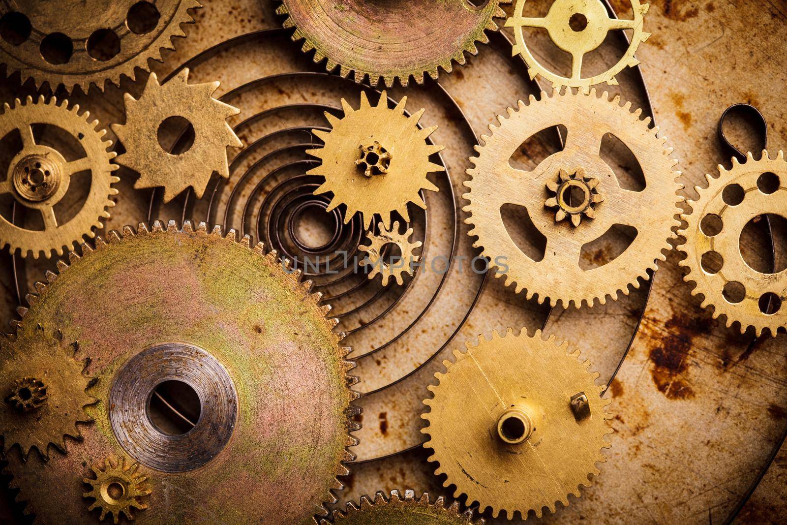 Steampunk background from mechanical clocks details over old metal background. Inside the clock, gears