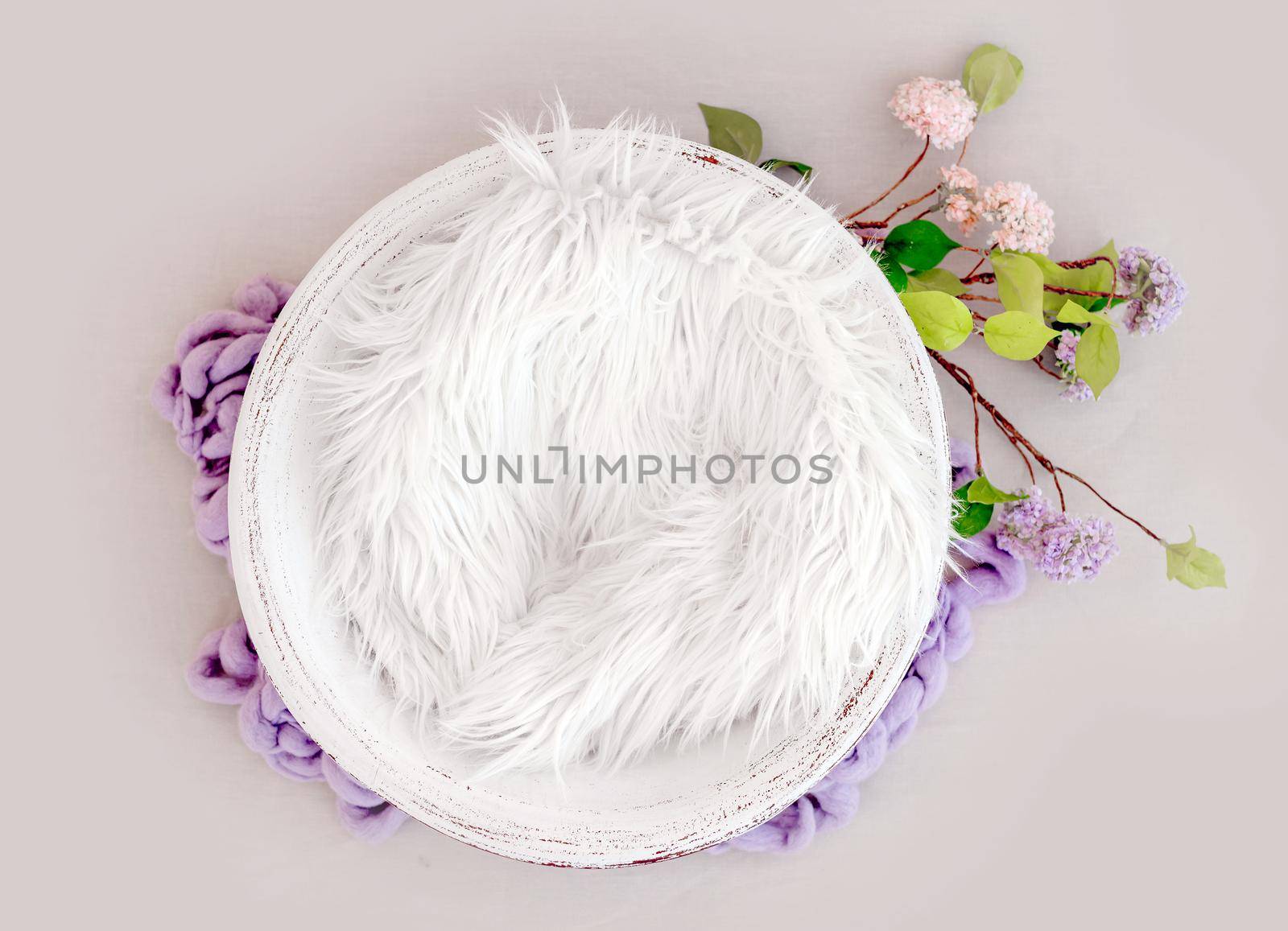 Beautiful backdrop for newborn photosession with flowers hydrangea. Digital composite with basin filled with knitted blanket isolated on light pink background