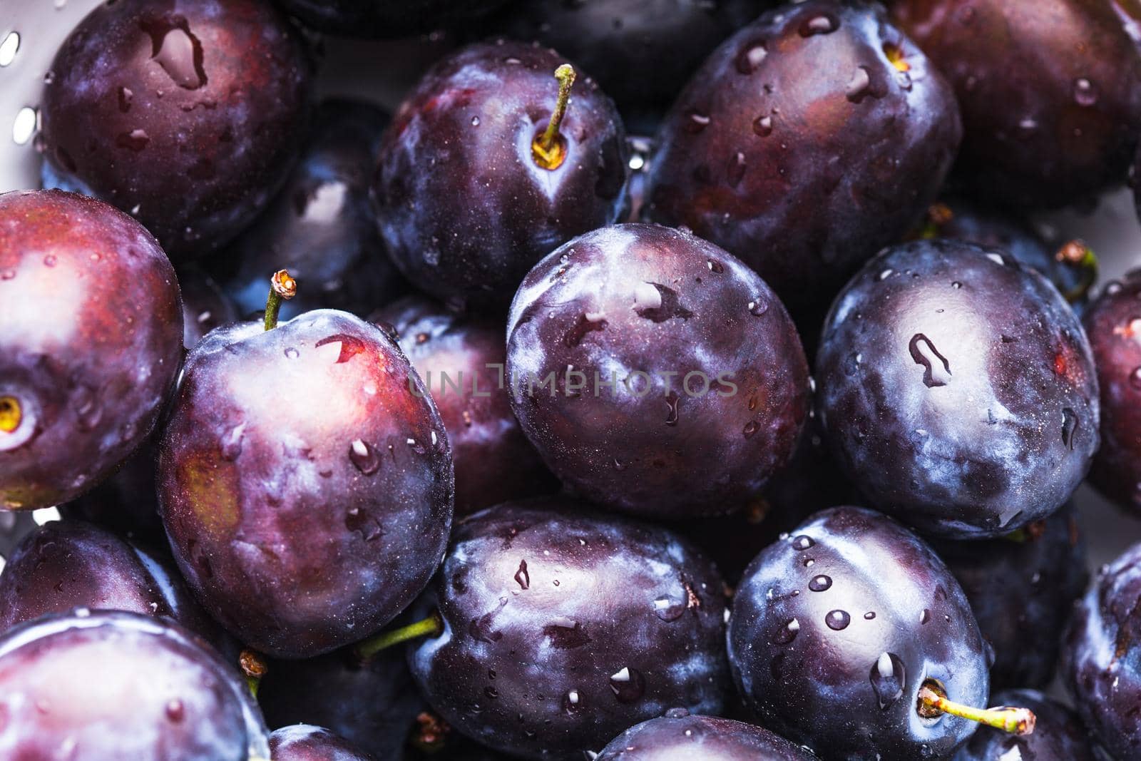 Fleshy wet plums close up as a background