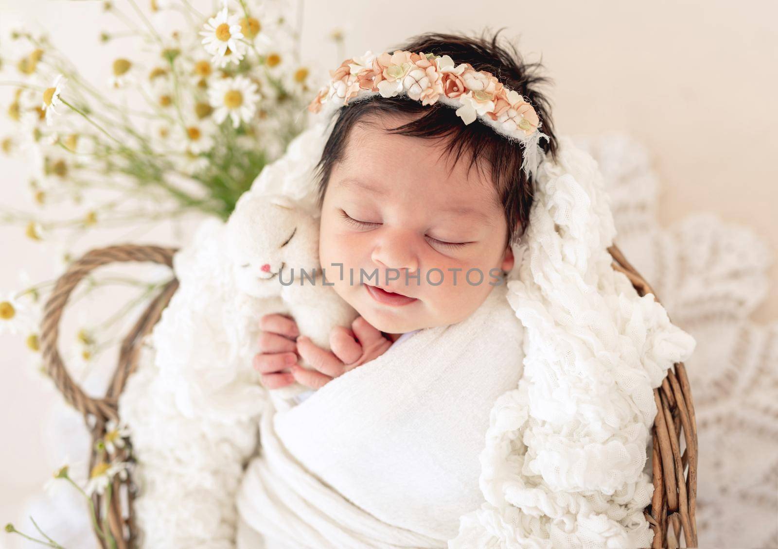 Adorable newborn sleeping in basket with toy