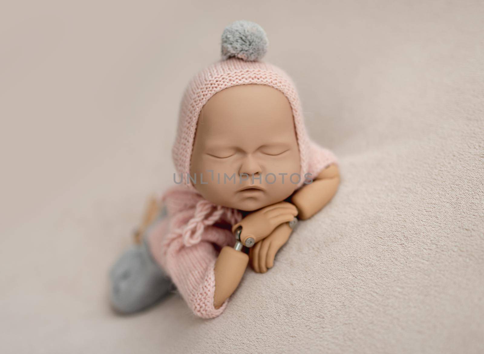 Precisely accurate mannequin of newborn in a knitted suit for photo practicing