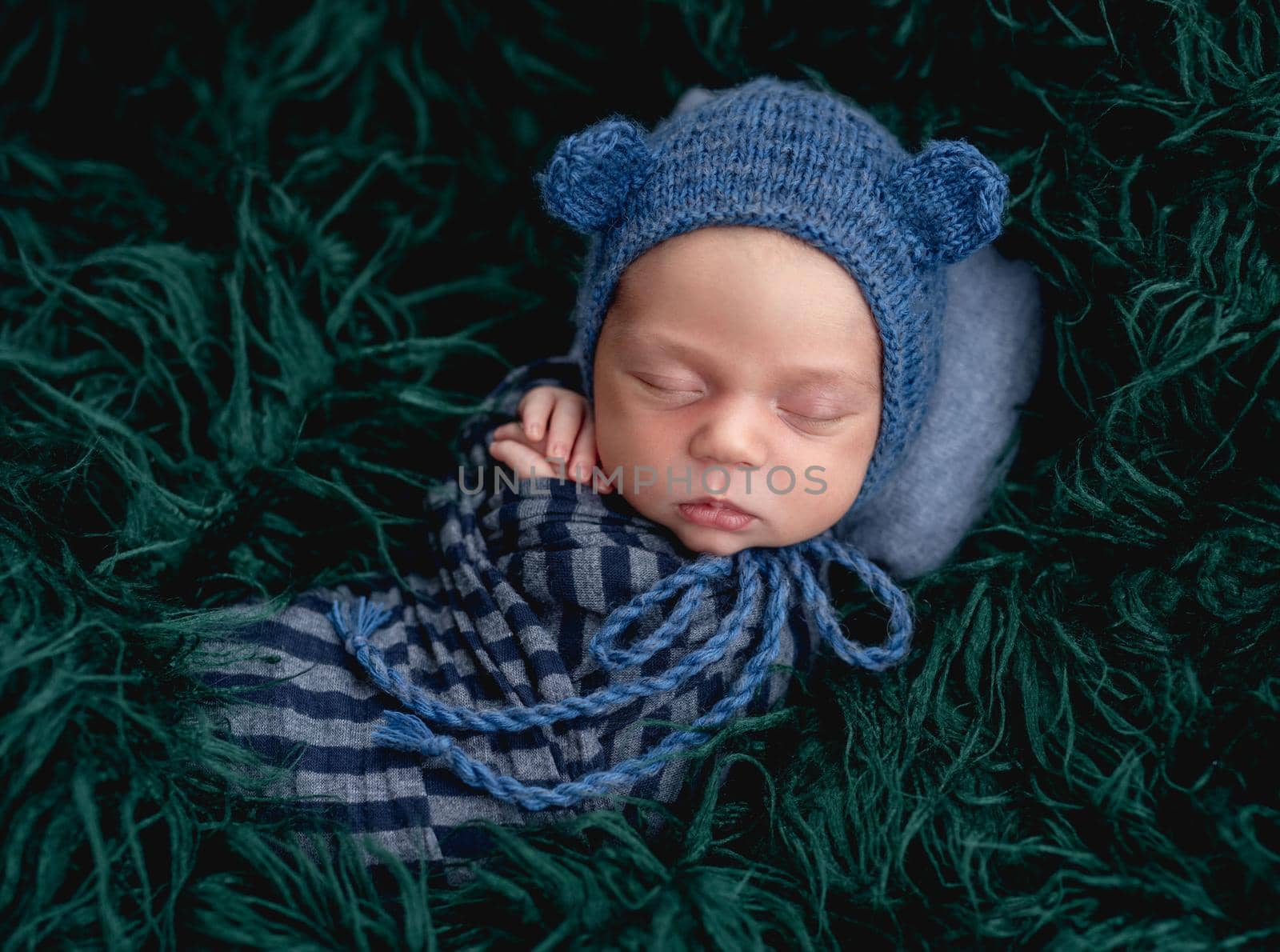 Cute sleeping newborn wearing blue knitted hat by tan4ikk1