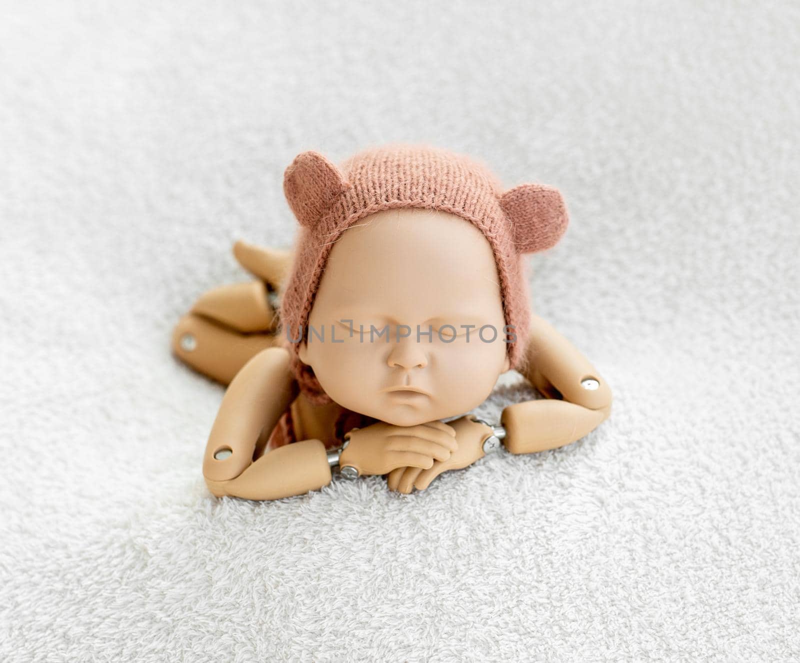 Precisely accurate mannequin of newborn in a hat for photo practicing