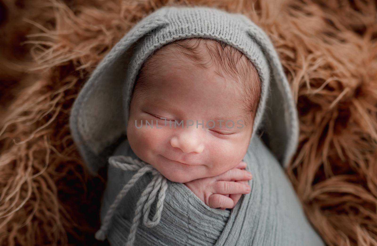 Portrait of smiling in dream newborn in funny knitted hat