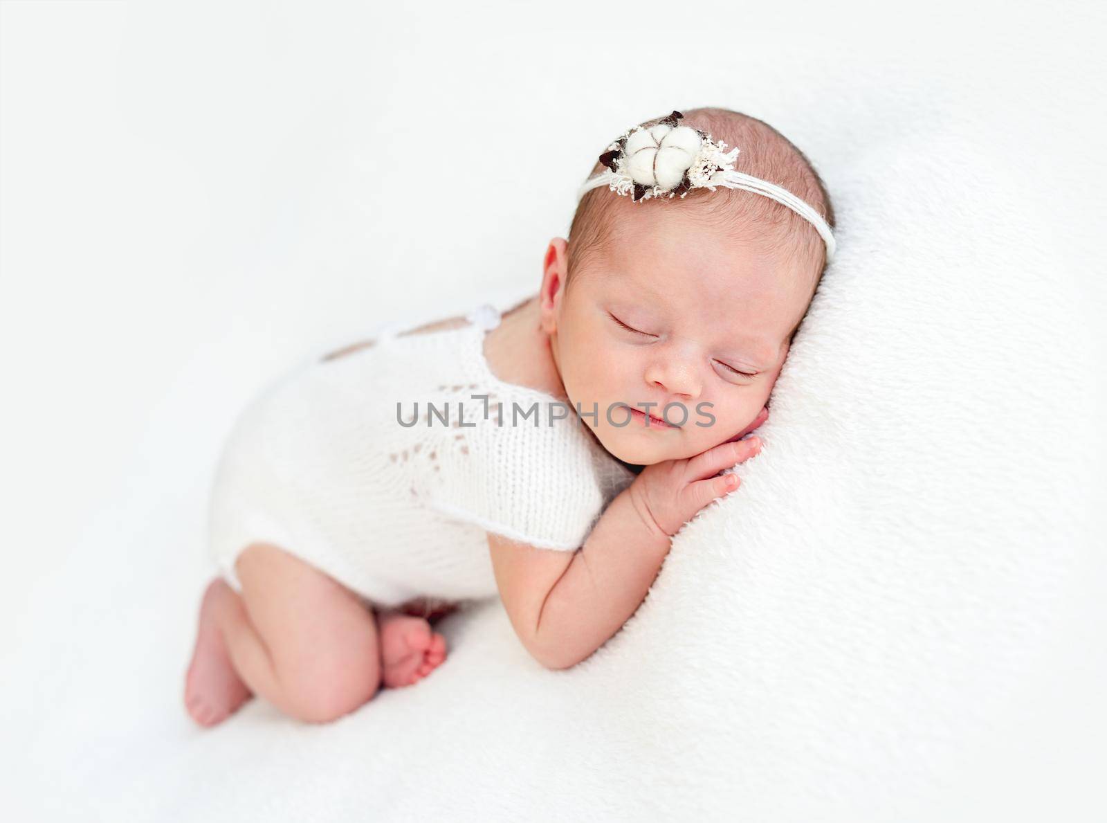 Sleeping newborn baby girl in knitted suit