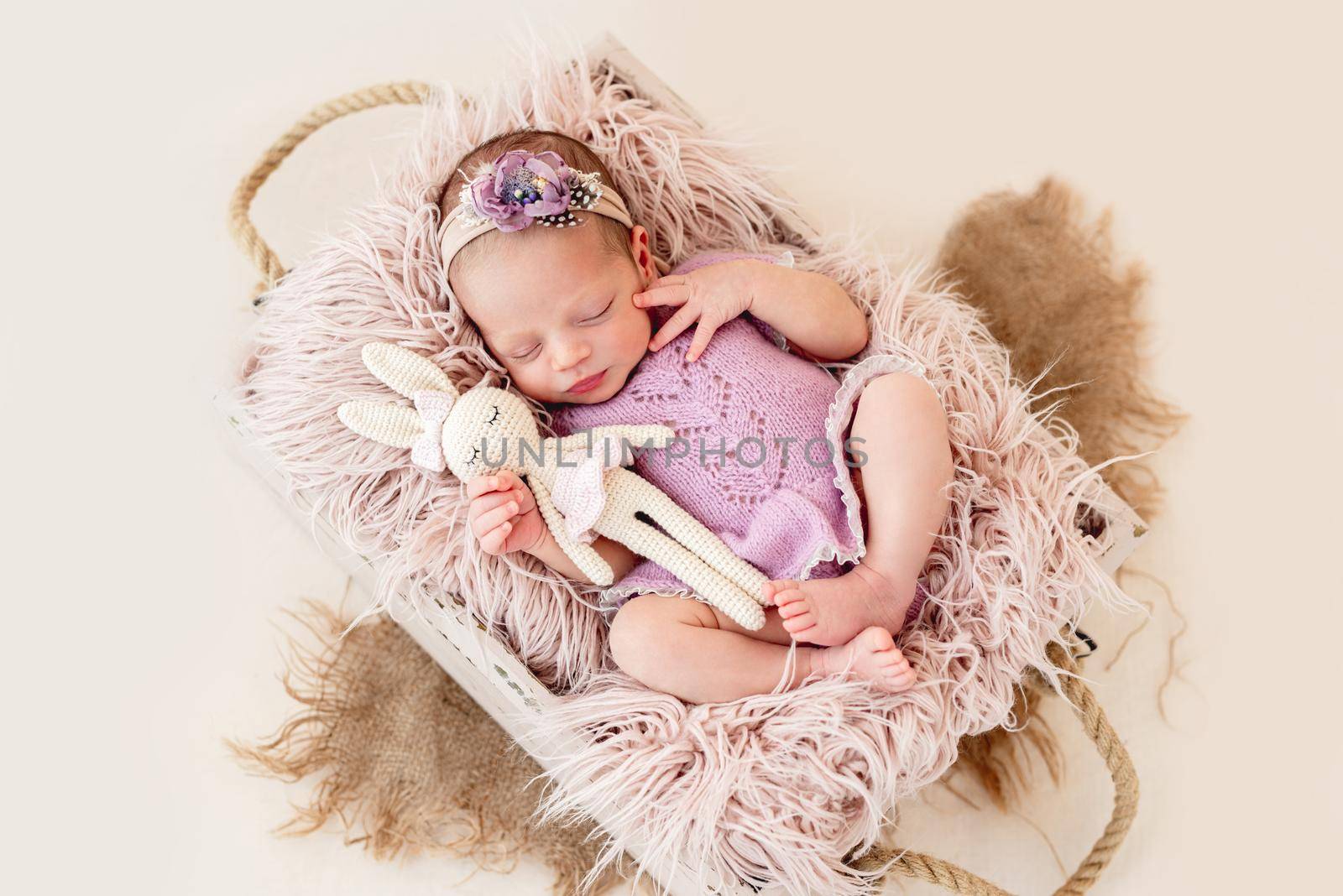 Sleeping newborn baby girl in a pink dress