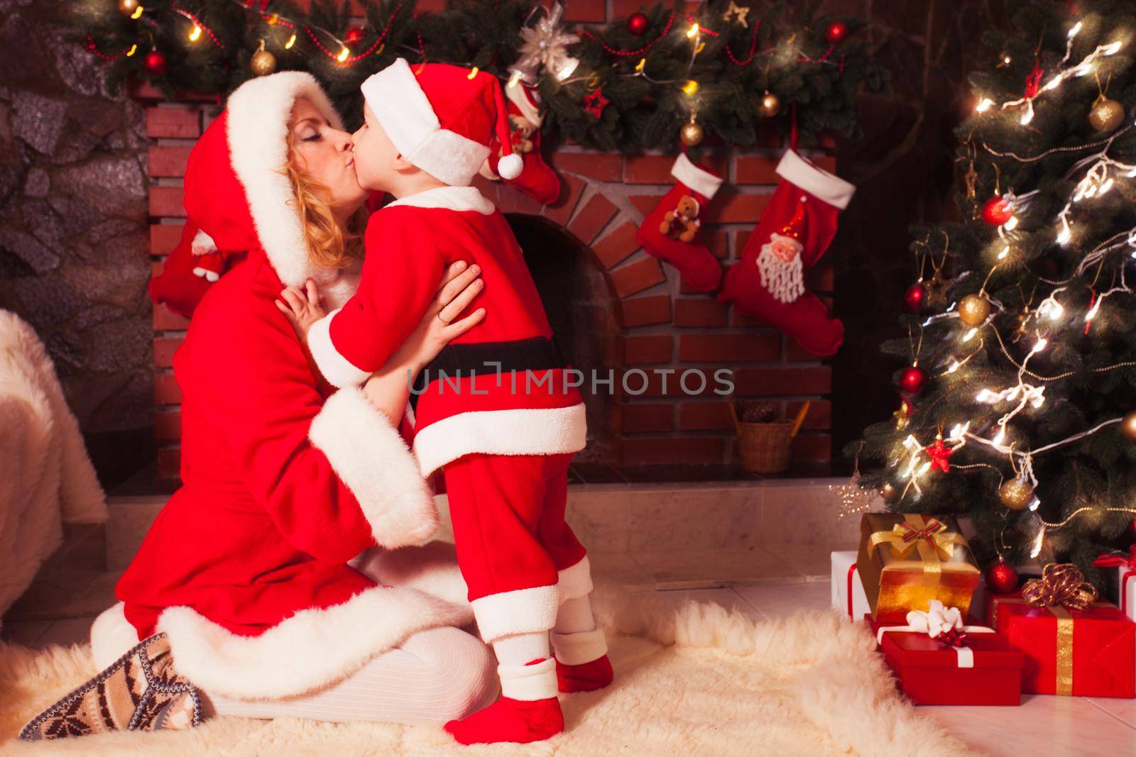 Mother and son in Christmas room with decorated tree and fireplace
