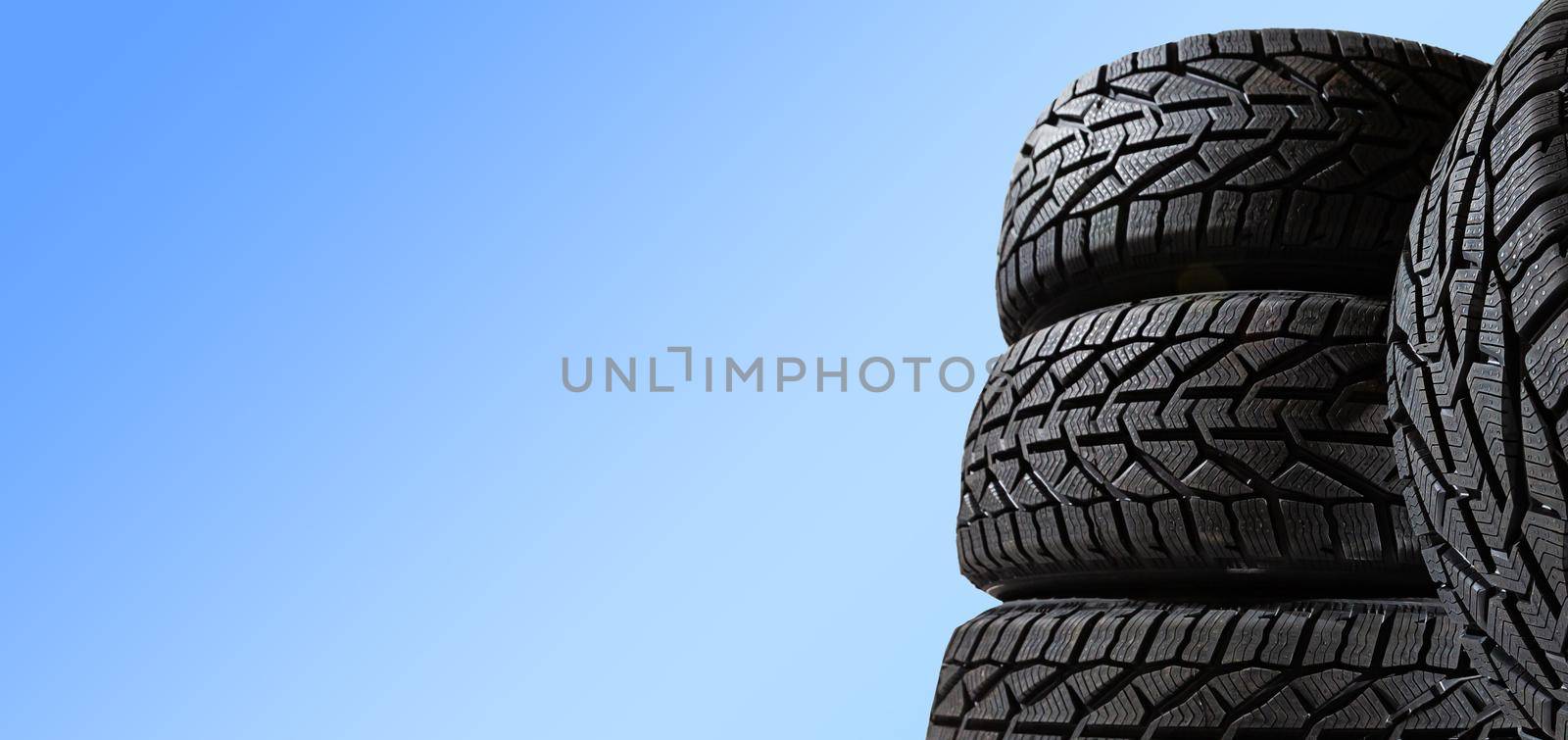 Winter car tires. Group of tires for winter driving on a blue background. by Andelov13
