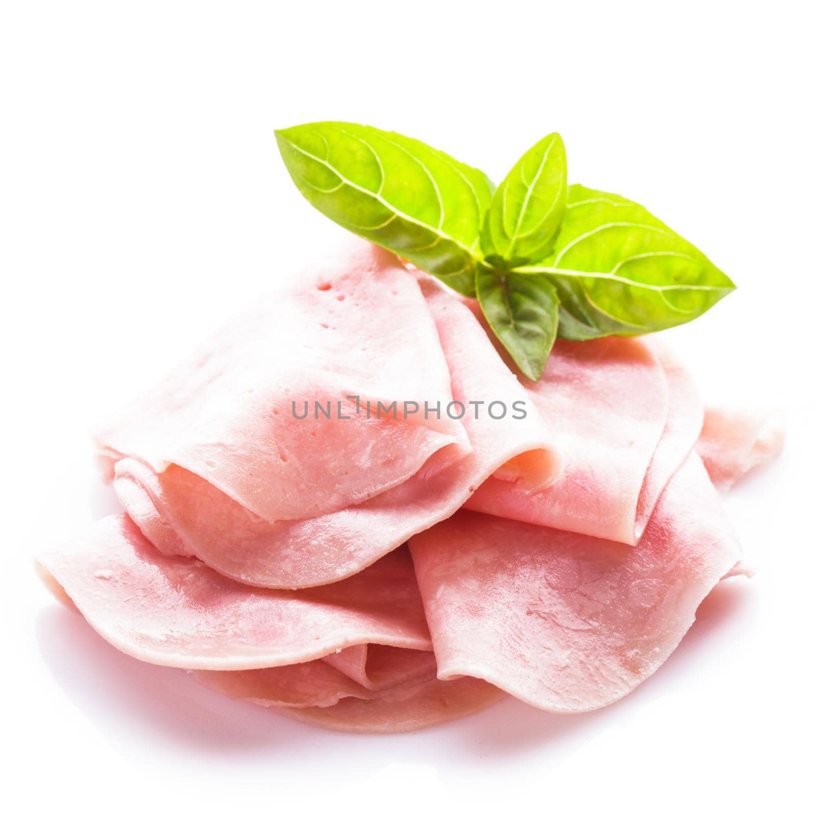 Ham slices isolated on white with green basil leaves