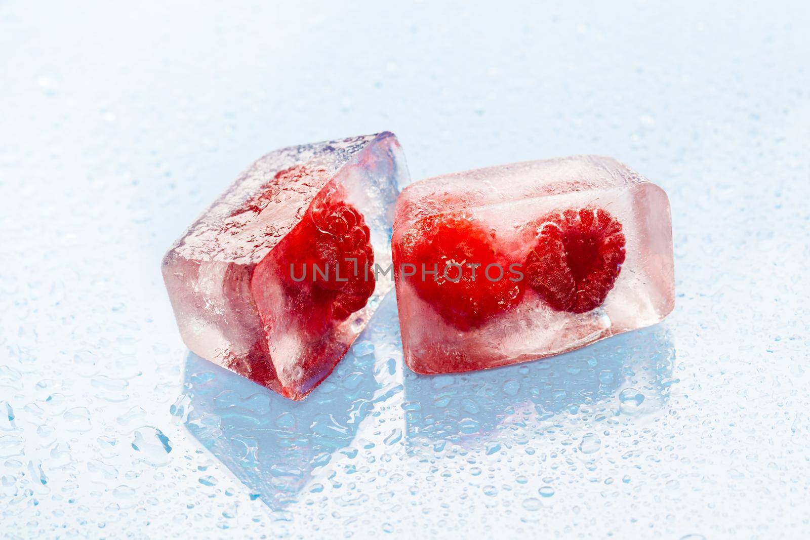Ice cubes with frozen berries inside close up by Fabrikasimf