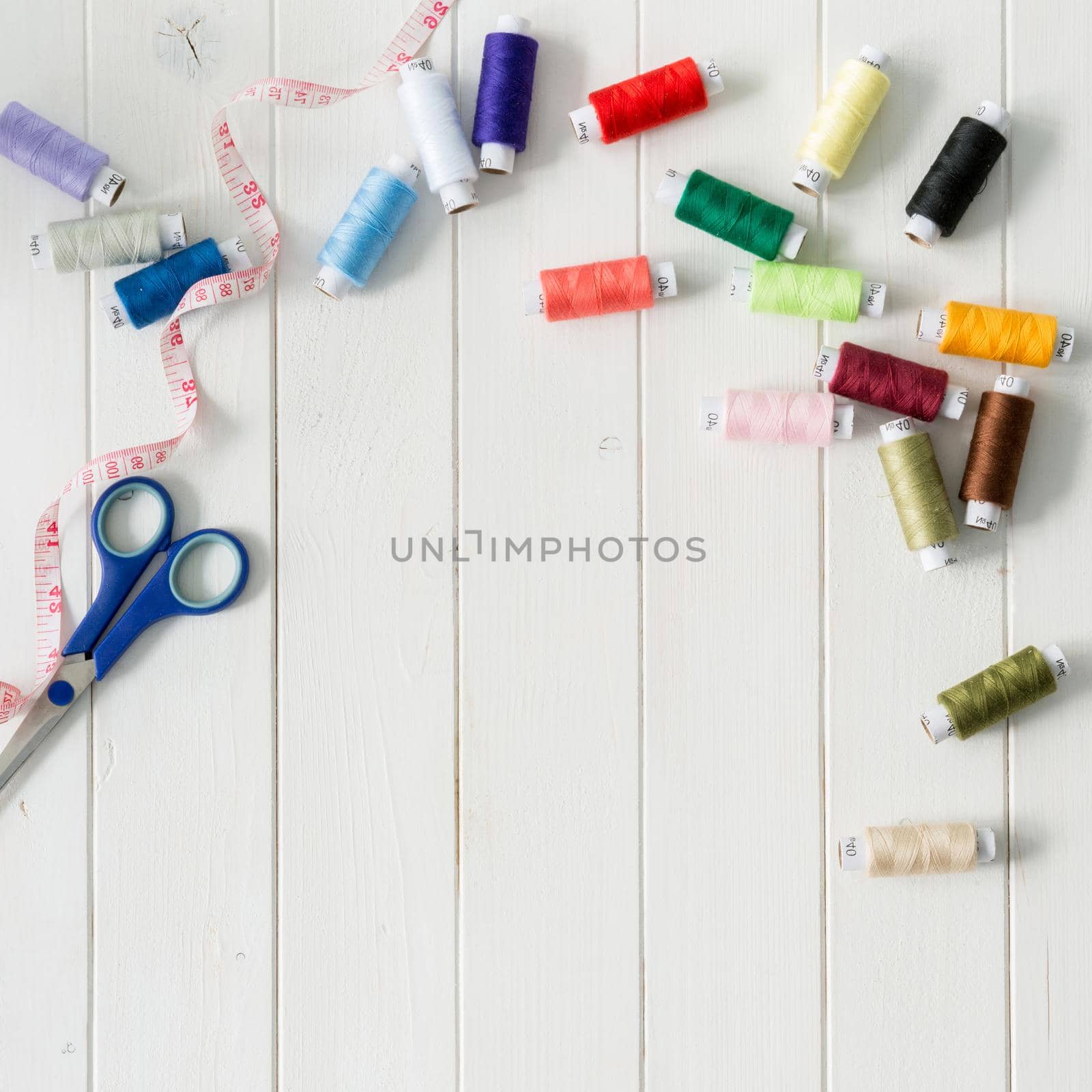 white wooden planks background with colorful thread skeins with text space