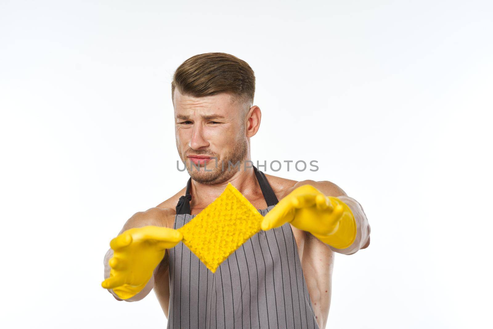a man in a gray apron wearing rubber gloves cleaning washing by Vichizh