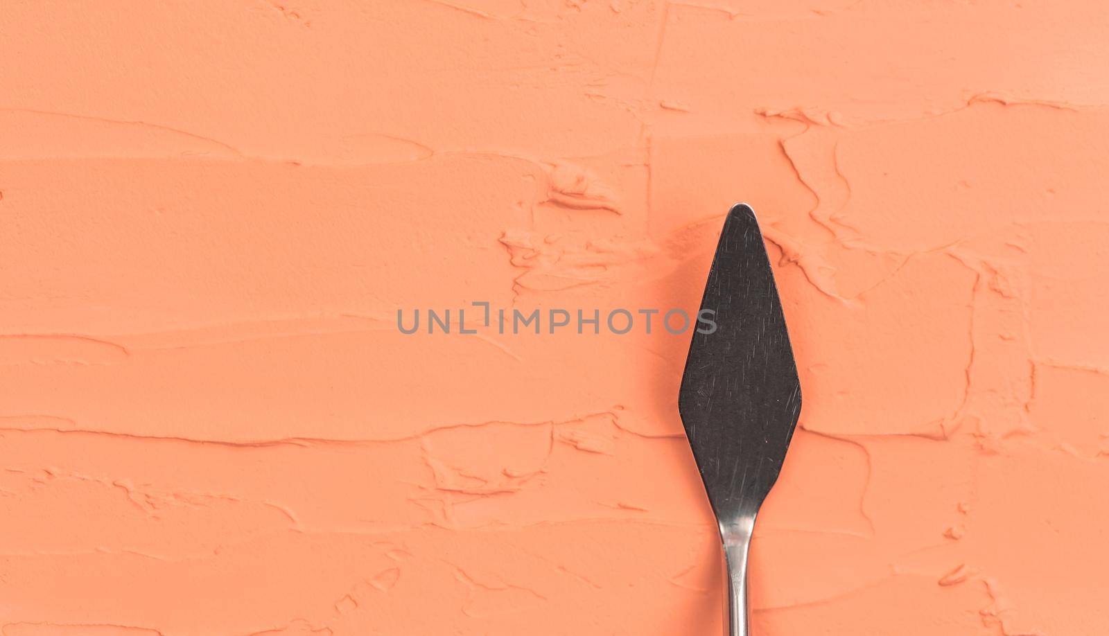 a painting palette knife isolated on a orange painted background painting with copy space